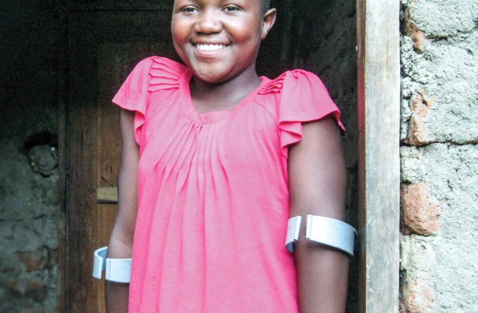 Ugandan Girl Locked in Closet for 6 Months After Accepting Christ a young girl stands in a door way with crutches smiling