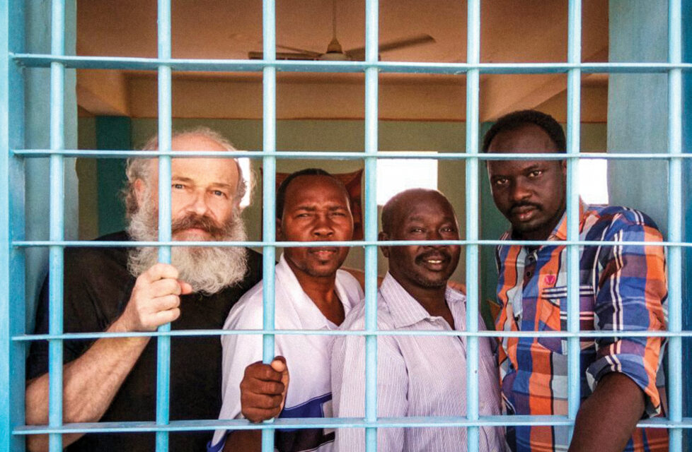 Petr Jasek Imprisoned with ISIS in Sudan four men stand behind bars in a jail cell