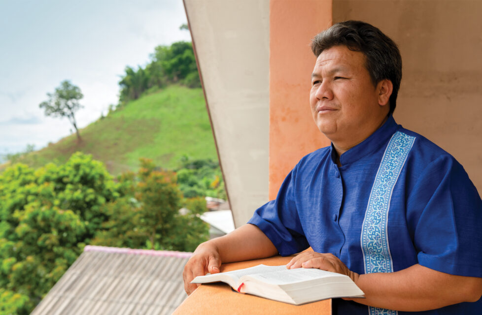 Hmong Pastor Jailed in Vietnam, Thanks God for Persecution A man sitting on his porch reading the Bible