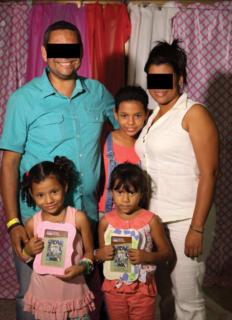 A family of 5 smiling at the camera