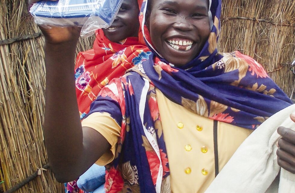 Greatest Eternal Gift Replaces Loss of all Earthly Possessions a woman smiles and holds up her new bible