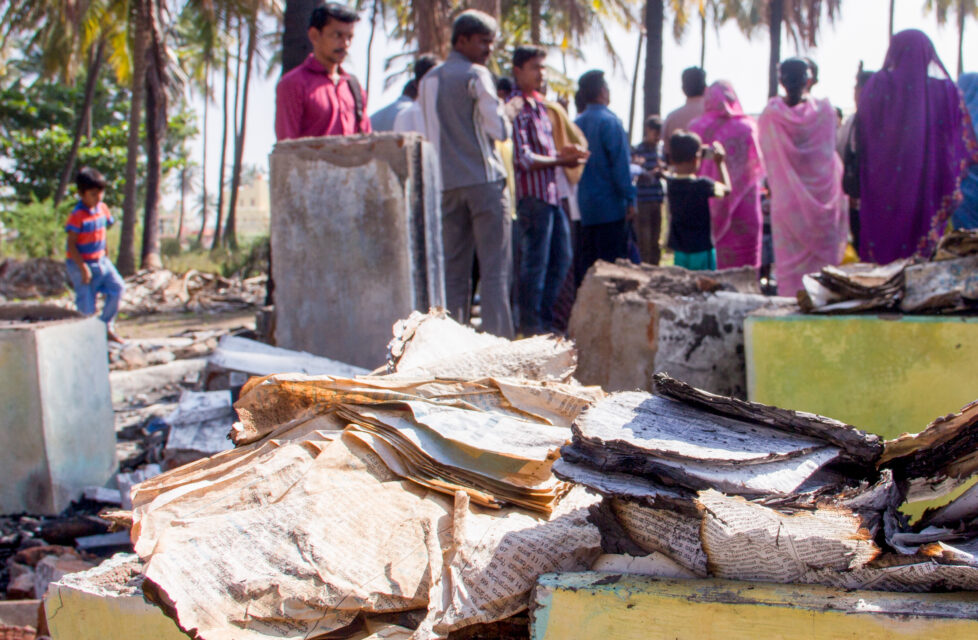 Former Hindu Cannot Live Without Her Bible A group of people gathered looking at a burned Bible