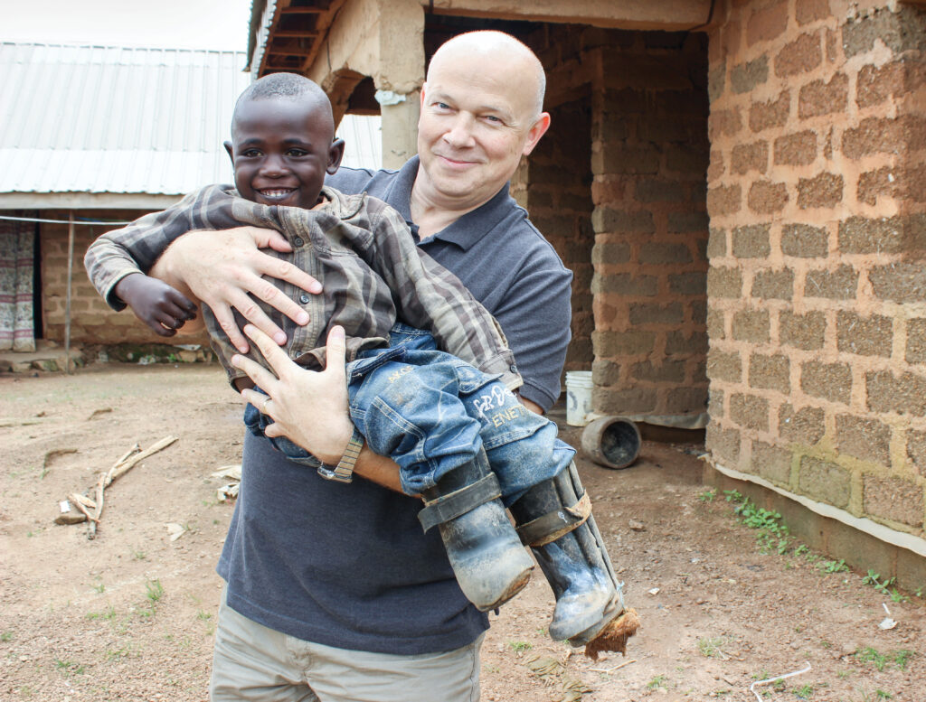 Man holding a little boy outside a building