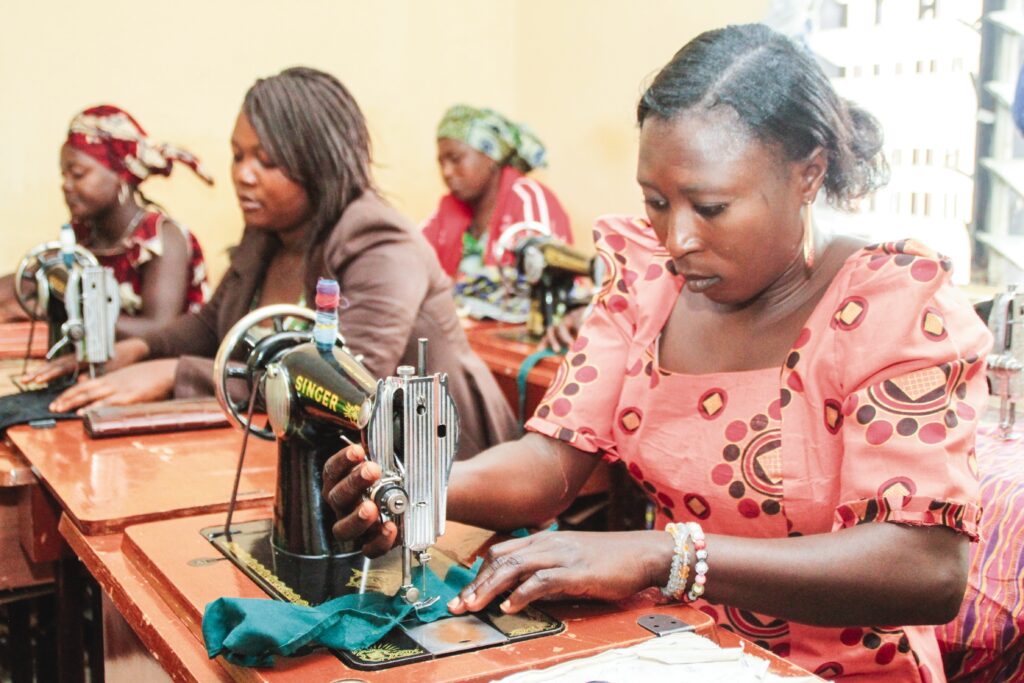 a group of women sewing on machines