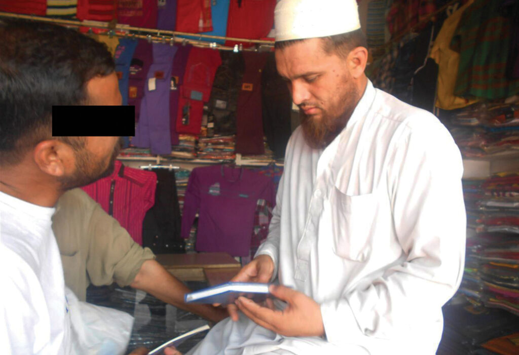 Man sits and shares the bible with another man