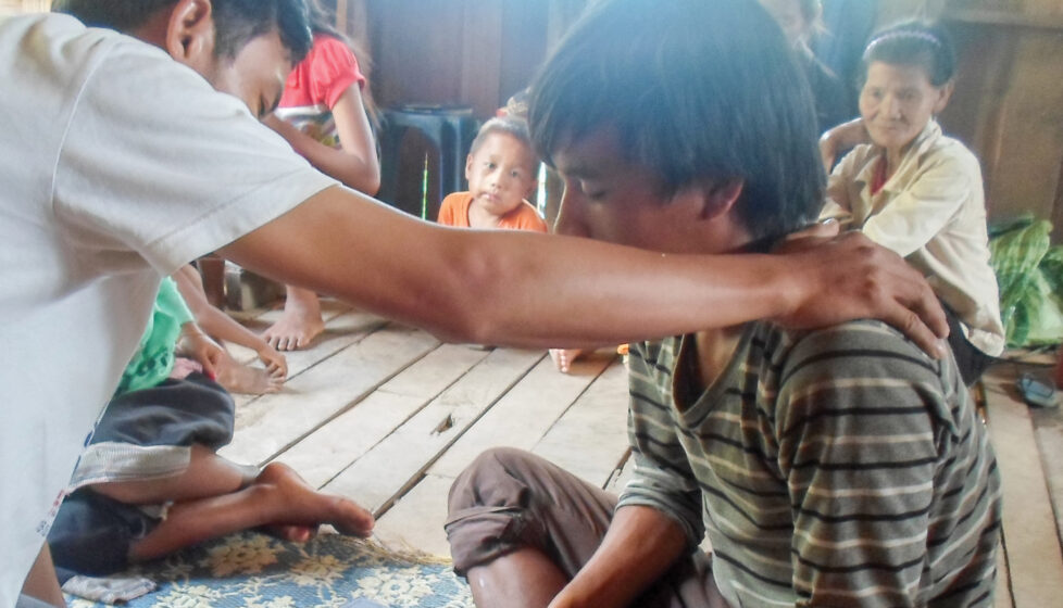 a man prays over a boy in church